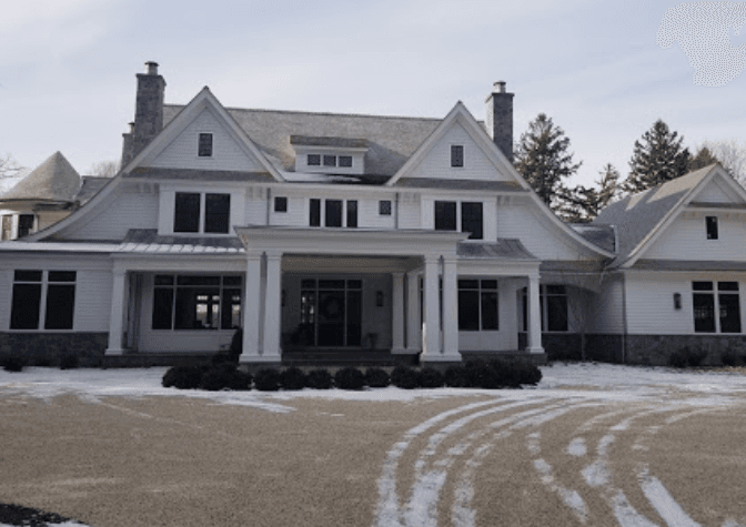A white two-story house with a front lawn